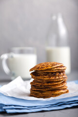 A stack of delicious pancakes with a bottle and a glass of milk on a gray background with space for text