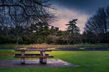 Wooden picnic table and benches on a stormy winter evening