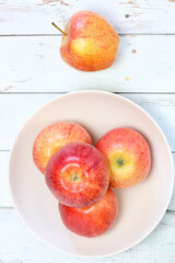 Manzanas maduras en un frutero sobre un tablero blanco