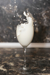 splashes of milk in a glass in the kitchen