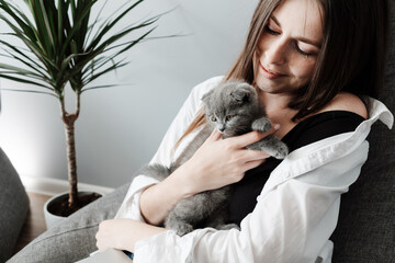 Young Adult Girl Working at Laptop from Home and Plays with Her Little Scottish Fold Cat, Concept of Remote Work, Freelance