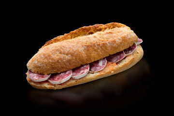 Baguette de salchichón sobre fondo negro. Iberian salami baguette on black background.