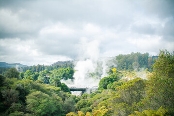 Clouds of steam rising over geothermal zone in the mountains