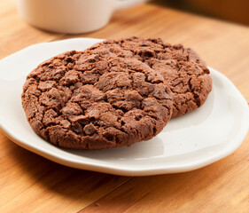 cookies de chocolate sobre plata en mesa de madera. chocolate cookies on silver on wooden table.