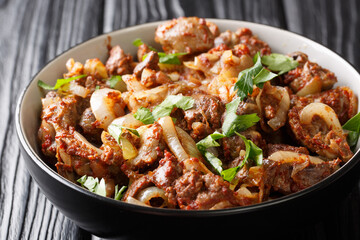 Armenian Tjvjik fried chicken offal liver, heart and stomachs with onions, tomatoes and spices close-up in a bowl. horizontal