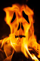 Flame fire skull against dark background as symbol of hell and eternal pain.