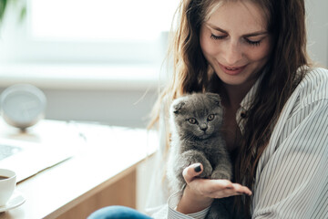Portrait of Young Adult Girl Working From Home with Her Little Cat, Freelance and Remote Work Concept