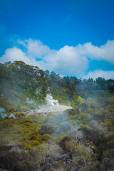 Clouds of hot steam rising from geothermal zone in mountains near Rotorua