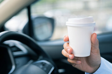 Man is drinking hot coffee in the car before going to work at the office every time.
