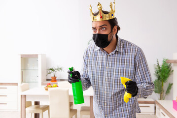 Young male contractor cleaning the house in coronavirus concept