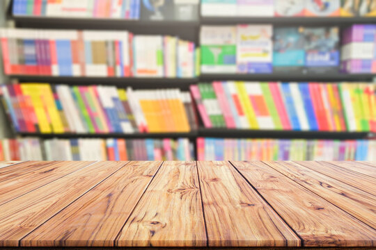 Table top wood desk and blurred bookshelf in the library room, education background, back to school concept