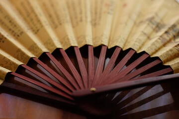 brown chinese style fan on the table, close up, side view.