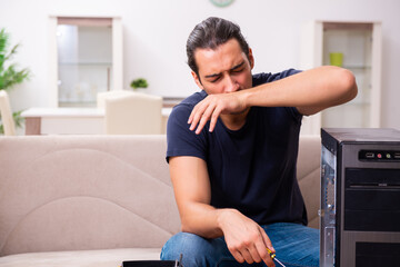 Obraz premium Young man repairing computer at home