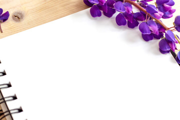 Beautiful purple flowers on a Notepad for writing. Background for presentation and design of graphic works.