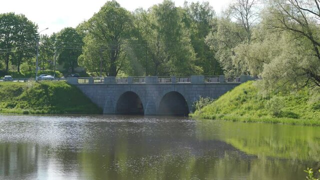 Stone bridge Marienthal pond Slavyanka river in Pavlovsk park on sunny spring day, Saint Petersburg, Russia.