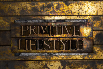 Primitive Lifestyle text formed with real authentic typeset letters on vintage textured silver grunge copper and gold background