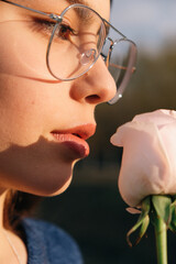 Portrait of beautiful and young girl holding rose flower closeup