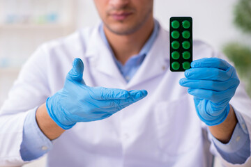 Young male lab assistant in drug synthesis concept