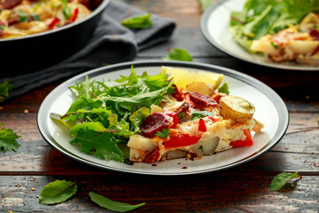 Chorizo Frittata with salad on black and white plate. healthy morning breakfast food