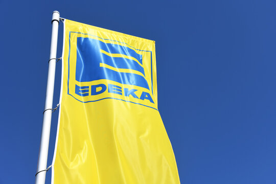 Nienhagen, Lower Saxony / Germany - April 21, 2018: Flag with the Logo of EDEKA in Nienhagen, Germany  -  The EDEKA Group is the largest German supermarket corporation