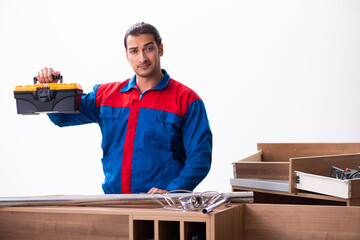 Young handsome male carpenter working indoors