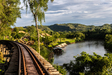 Railway bridge on a cliff along the river under blue sky on sunny day. 