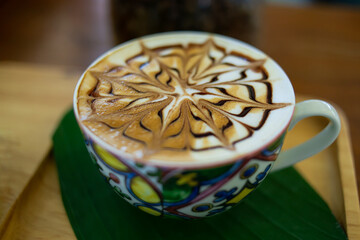 Hot latte coffee in a cup with a beautiful pattern