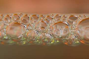 Blurred background with water line and bubbles in brown tones in high magnification.