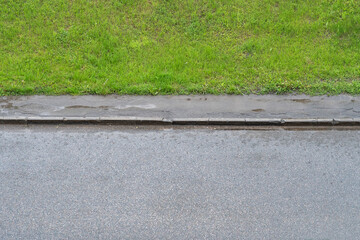 Fototapeta premium Wet road with sidewalk and lawn