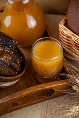 Homemade bread kvass. Summer carbonated soft drink. Glass and carafe on a wooden table. Black Overseas Rye Bread - Ingredients for a Drink. Copy space. Traditional cold rye drink Kvas in a jug.