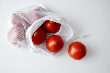 Fresh organic farm tomatoes in eco bag. Zero waste food shopping. Reuse, recycle, reduce, refuse. Flat lay. Copy space.
