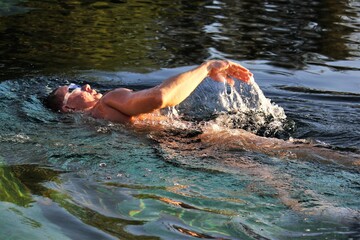 Swim training in pool. Man swimming front crawl