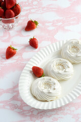 high angle empty meringue nests on a platter with strawberries