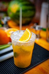 Cocktail preparation with orange, mint, maracuja and ice.