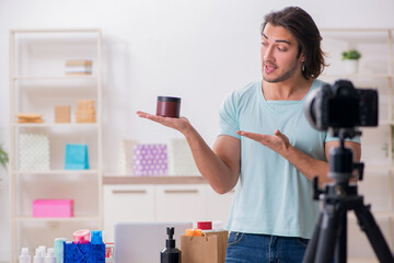 Young male shopaholic recording video for his blog