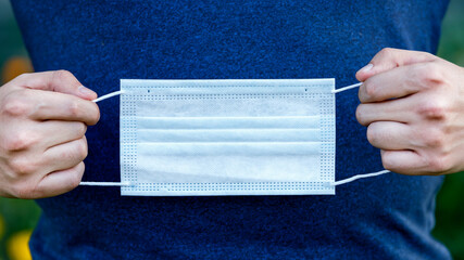 Hands holding a protective medical mask protection against covid