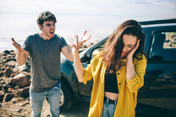 Family quarrel near the car. Scandal and disagreement concept. Crisis in the family. Husband screams at his wife. Couple wants a divorce.
