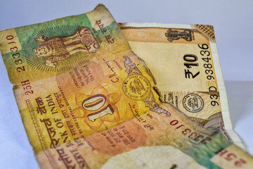 Old 10 rupees Indian currency note and new 10 rupees currency notes kept together on white background.