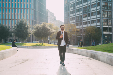 Young man contemporary businessman walking outdoor using smartphone - Modern businessman outdoors using cellphone remote working