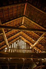 Interior of old wooden shed with scrap wood with sunrays