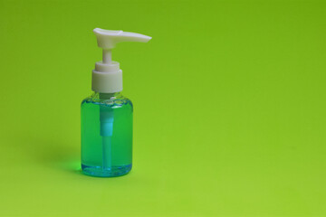 Close up, disinfecting hand gel on green background, space for text