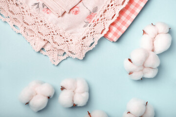 Cotton bolls and napkins made of cotton fabric on a blue background