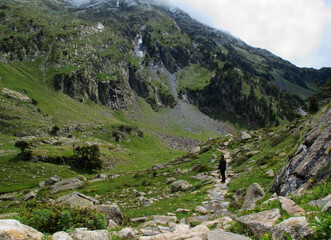 a person walks on a path between big mountains

