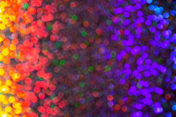 Abstract rainbow festive shining defocused background with texture of multicolored holographic neon bright colorful bokeh in dark magic tones