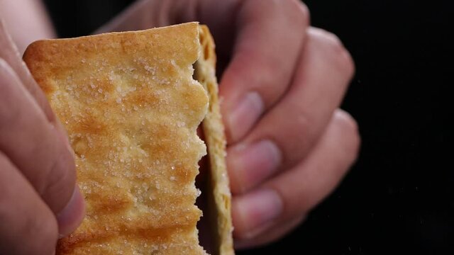 Hands breaking cracker with sugar in slow motion