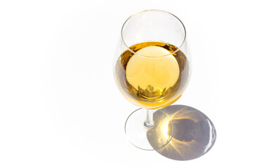 glass of white wine on white background with sparkling shadows. Free copy space.  Concept of luxury drinks. Top view.