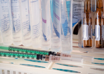 Syringes, ampoules with medicine, saline on a shelf. Medical background for business, pharmacies,...