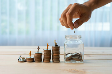 A close-up of a hand of a man who is putting coins in a piggy bank. saving money financial concept.
