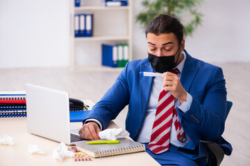Sick male employee suffering at workplace from coronavirus