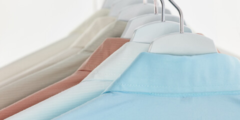 Fototapeta na wymiar Men's dress shirts, Clothes on hangers on white background
